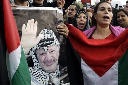 Un grupo de palestinos, en su mayoría mujeres, guarda vigilia ante las puertas del hospital militar de Percy.