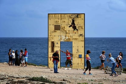 Un grupo de turistas se toman fotos en la 'Porta di Lampedusa' o 'Puerta de Europa', un monumento en recuerdo de los fallecidos en el peor naufragio de la historia de Lampedusa.