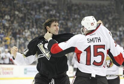 El defensa Roberto Bortuzzo de los Pittsburgh Penguins y Zack Smith de los Ottawa Senators luchan durante el primer período en el Consol Energy Center. Los Pittsburgh Penguins ganaron 2-1 en el tiempo extra.