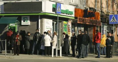 Personas guardan turno para retirar dinero de un banco en Simferópol.