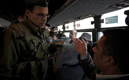 Un soldado israel&iacute; pide la documentaci&oacute;n a un palestino en un autob&uacute;s, en el puesto de control de Hizme, antes de entrar en Jerusal&eacute;n.