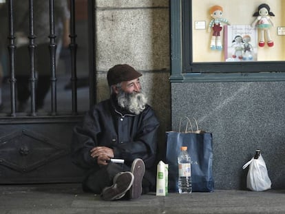 Un mendigo, un hombre mayor, pide limosna en los soportales de la plaza Mayor de Madrid. 