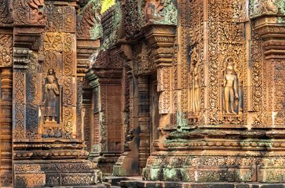 BANTEAY SREI. A unos 30  kilómetros al norte del emblemático templo de Camboya, Angkor Wat, Bateay Srei es un delicioso santuario consagrado al dios Shiva y cuya construcción en el año 970 fue encargada a mujeres artistas y obreras, al parecer más capacitadas en aquellos días para la elaboración de sus exquisitas tallas de reducido tamaño que adornan los muros de una construcción que es también casi una miniatura, debido, según la leyenda que rodea a esta obra maestra del Arte Jemer, a las manos más pequeñas de las mujeres camboyanas en comparación de sus colegas masculinos.