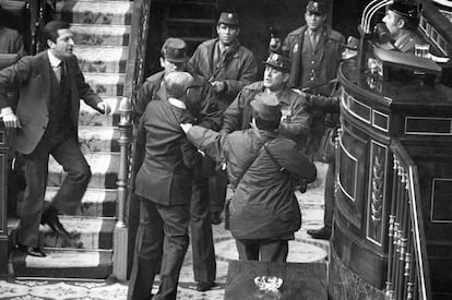 Manuel Gutiérrez Mellado, vicepresidente primero del Gobierno en funciones, se levanta de su escaño y se enfrenta a los agentes armados. Un guardia civil zarandea al exministro de Defensa. A pesar de su aspecto frágil y sus 69 años, no consigue derribarle. El presidente Adolfo Suárez se encara con los guardias civiles. El cámara de TVE Pedro Marín, situado en la tribuna de prensa, sigue grabando y retransmitiendo a una unidad móvil este momento que convierte a Gutiérrez Mellado en un mito y un icono de la Transición; después del “¡Quieto todo el mundo! ¡Al suelo! ¡Se sienten, coño!” de Antonio Tejero (a la derecha, detrás de la tribuna), claro.