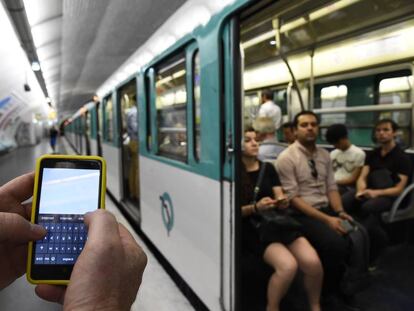 Un hombre sujeta un móvil en el metro de París