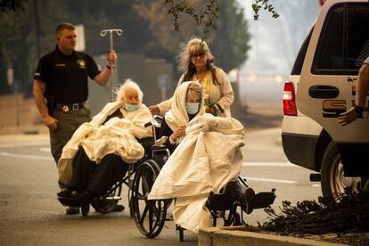 Miembros del personal de emergencias evacuan el pasado jueves a varios pacientes del hospital Feather River, en Paradise (California), ante el incendio que castiga desde hace días esta localidad.