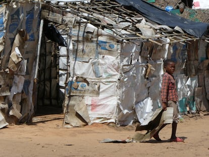 Un niño transporta un cartón, material que sirve para construir las casas, en el campo de desplazados de Maringanha, en la ciudad de Pemba, en Cabo Delgado.