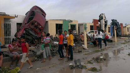 Varios residentes observan los daños causados por el tornado.