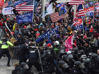 Multidão de seguidores de Donald Trump quebra a barreira de segurança levantada pela polícia diante do Capitólio em 6 de janeiro.