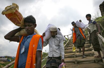 Refugiados rohingya caminan con donaciones de alimentos en Cox's Bazar (Bangladés). Tras la consulta realizada, ACNUR ha emitido un comunicado indicando que ninguna de las personas entrevistadas "ha indicado su disposición a ser repatriado en estos momentos".