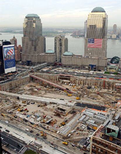 Aspecto que presentaba ayer el solar que ocupaban las Torres Gemelas. Una gigantesca bandera de EE UU aparece colocada en la fachada del World Financial Center. La torre de la izquierda es el edificio Dow Jones. VISTA AÉREA
 - PAISAJE URBANO