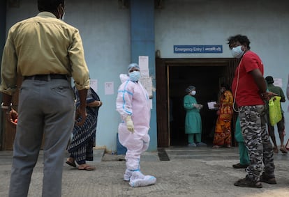 Un trabajador sanitario atiende a los familares de los ingresados por coronavirus en el hospital de Calcuta (Bengala Occidental).