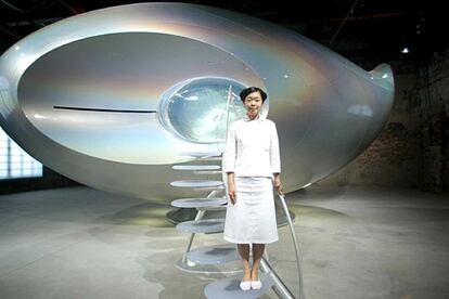 La artista japonesa Mariko Mori posa junto a su OVNI expuesto en la Bienal.