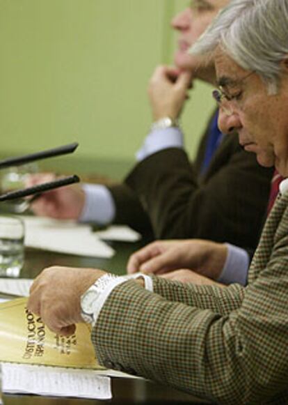 Manuel Huertas consulta la Constitución durante la rueda de prensa.