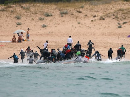 Moroccan migrants disembark from a dinghy at 