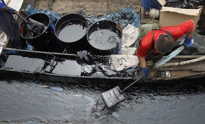 Un pescador recoge crudo en China tras un vertido en 2010.