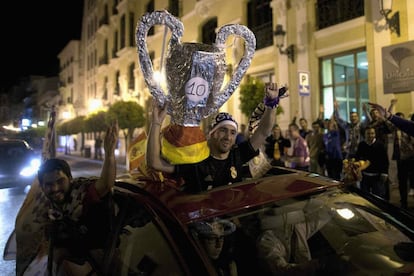 Aficionados del Real Madrid circulan en coche por una calle céntrica de Ronda portando una copa de cartón para festejar el triunfo del Real Madrid ante el Atlético en la final de la Champions.