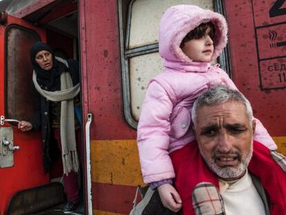 Tres migrantes esperan este mi&eacute;rcoles en un tren para cruzar la frontera entre Grecia y Macedonia. 
 