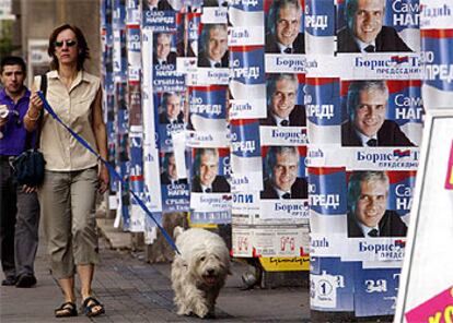 Una mujer pasea a su perro por una calle de Belgrado repleta de carteles del candidato reformista Boris Tadic.