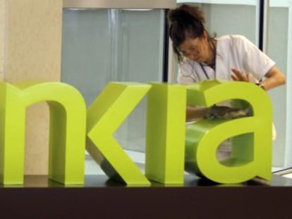 Una operaria limpia el logo de Bankia.