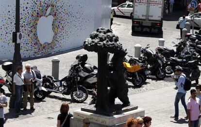 A la izquierda, los paneles que cubren la tienda de Apple en la Puerta del Sol de Madrid. En el centro, la estatua del Oso y el Madroño