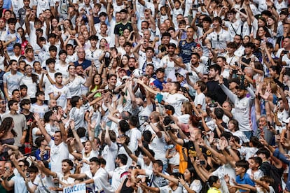 Aficionados del Real Madrid pugnan por el balón lanzado por Mbappé. 