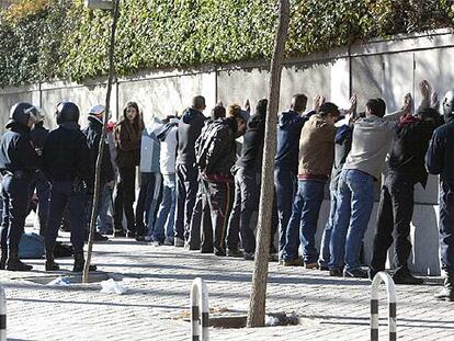 Agentes de policía retienen a un grupo de jóvenes tras los disturbios que provocaron en la calle de Serrano.