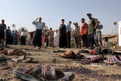 Varios iraquíes observan las sandalias de las víctimas tras un ataque de insurgentes al norte de Bagdad.