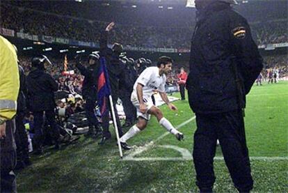 Figo, rodeado de policías, intenta sacar un córner en el Barcelona-Real Madrid.