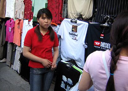 Una vendedora china en un puesto de ropa falsificada en un mercadillo de Pekín.