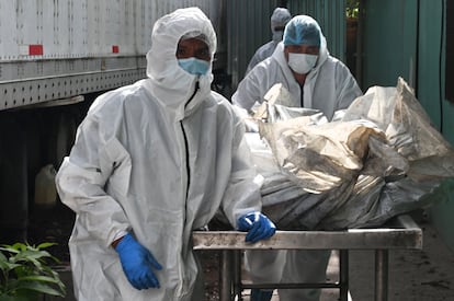 Forensic employees transport the corpses of several of the 46 dead women during a fire following a brawl between inmates of the Women's Social Adaptation Center (CEFAS) prison in Tegicugalpa, on June 21, 2023.