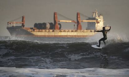 Un surfista toma una ola frente a la costa de Tynemouth (Reino Unido).