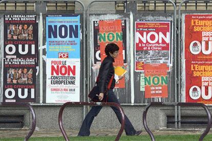 Una mujer pasa ante carteles por el <b><i>sí</b></i> y por el <b><i>no</b></i> en una calle de Lille (Francia).