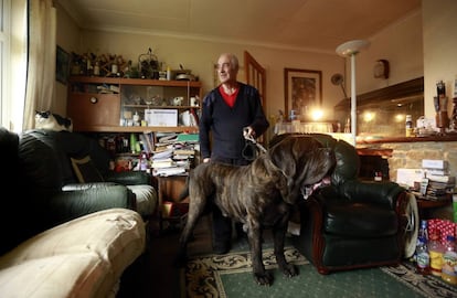 Rickie Haughton de 70 años, posa en el interior de su casa con su perro, un mastín Inglés. Haughton asegura que su mascota sería lo primero que rescataría de su vivienda.