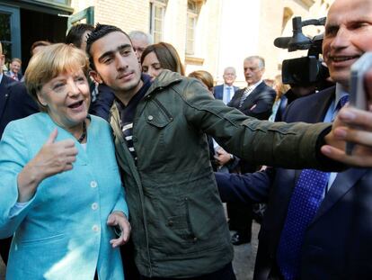 Anas Modamani com Angela Merkel, quando ele tirou uma selfie com a chanceler.