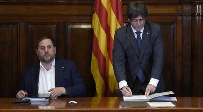 Carles Puigdemont y Oriol Junqueras este mi&eacute;rcoles durante la firma de la ley del refer&eacute;ndum del 1 de octubre en Catalu&ntilde;a.