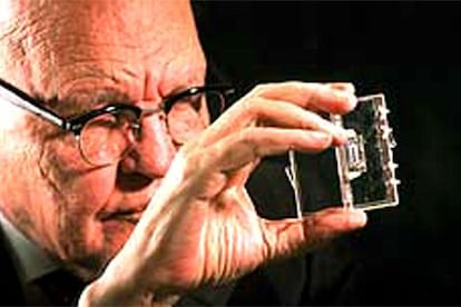 Jack Kilby, con un circuito electrónico integrado en la mano.