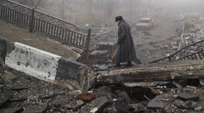 Una mujer camina sobre un puente destrozado cerca del aeropuerto de Donetsk, en el este de Ucrania.
