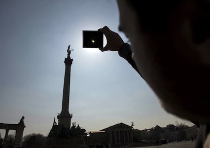 Un hombre observa el eclipse solar en Hungría.