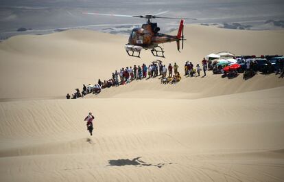 Un helicóptero observa a un motorista durante la primera etapa del Dakar.