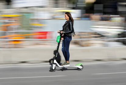 Una mujer en un patinete eléctrico en una calle de Madrid.