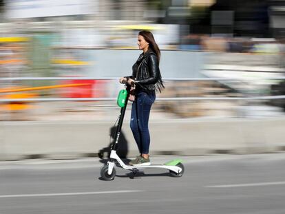 Una mujer en un patinete eléctrico en una calle de Madrid.