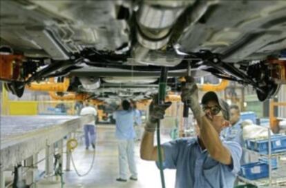 Un hombre en una cadena de montaje de autos