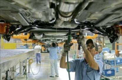 Un hombre en una cadena de montaje de autos