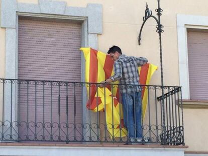 Un mosso descuelga la estelada del Ayuntamiento de Nav&agrave;s. 