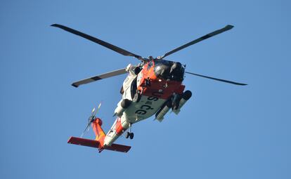 A U.S. Coast Guard helicopter flies over the Venice Fishing Pier Thursday morning, April 6, 2023, as emergency crews search a debris field in the Gulf of Mexico after a small airplane crash Wednesday night. (Mike Lang/Sarasota Herald-Tribune via AP)