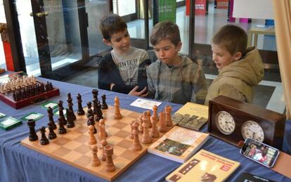 Tres niños visitan la exposición paralela a las III Jornadas de Ajedrez Infantil de Sabadell.