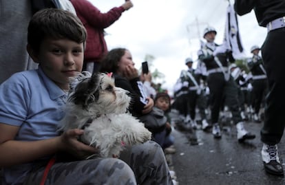 Un niño sujeta a su perro durante un desfile de la Policía Nacional en Bogotá (Colombia), el 20 de julio de 2019.