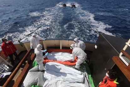 Salvavidas de la ONG española 'Proactiva Open Arms' desinfectan cinco cadáveres de migrantes, después de una operación de búsqueda y rescate en el centro del mar Mediterráneo frente a la costa de Libia.
