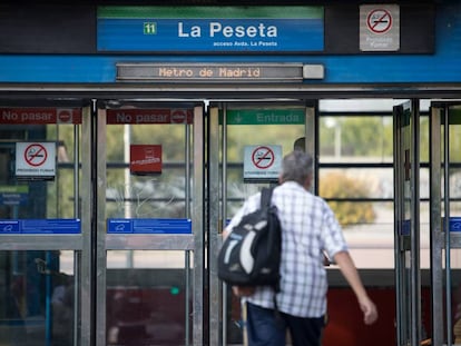 Un hombre entra a la estación de La Peseta, en la línea 11 del metro de Madrid.